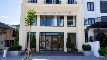 Das Hotel Horizon Minh Chau mit moderner Fassade, großen Fenstern und einladendem Eingang.