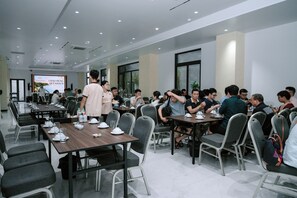 A conference room with multiple tables and chairs, equipped with nameplates and water bottles.