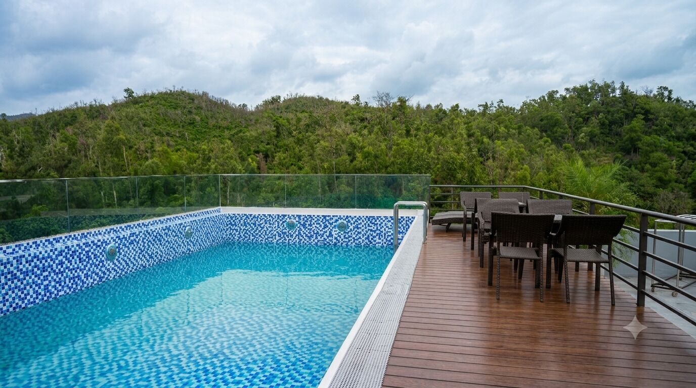 Une piscine dont le bord est revêtu de carreaux, entourée d’une terrasse en bois et agrémentée de mobilier d’extérieur.