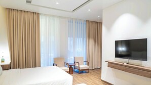 A hotel room with two beds, a TV, a desk, and a chair. - HORIZON MINH CHAU HOTEL (Van Don)