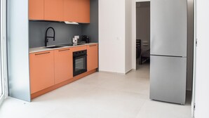 A modern kitchen with a built-in oven, a stainless steel refrigerator, and a grey backsplash. - Nice home in Marina di Ragusa (Marina di Ragusa)