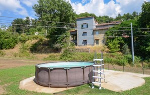 A swimming pool with a ladder, surrounded by a grassy area and a house in the background. - Amazing home in Arcidosso (Arcidosso)