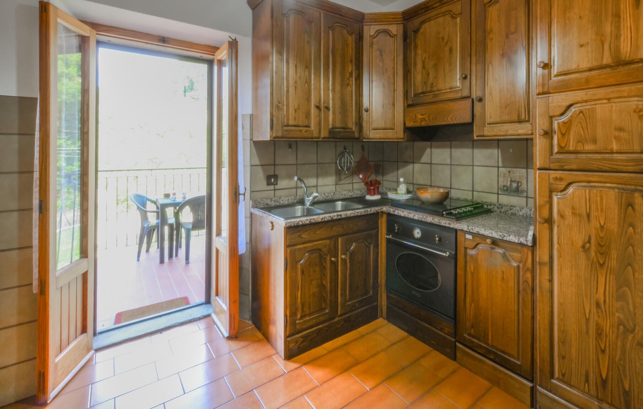 A kitchen with wooden cabinets, a sink, and a stove.