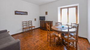 A dining area with a round table, chairs, a television, and a cabinet. - Amazing home in Arcidosso (Arcidosso)
