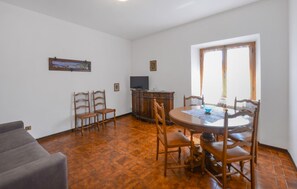 A dining area with a round table, chairs, a television, and a cabinet. - Amazing home in Arcidosso (Arcidosso)