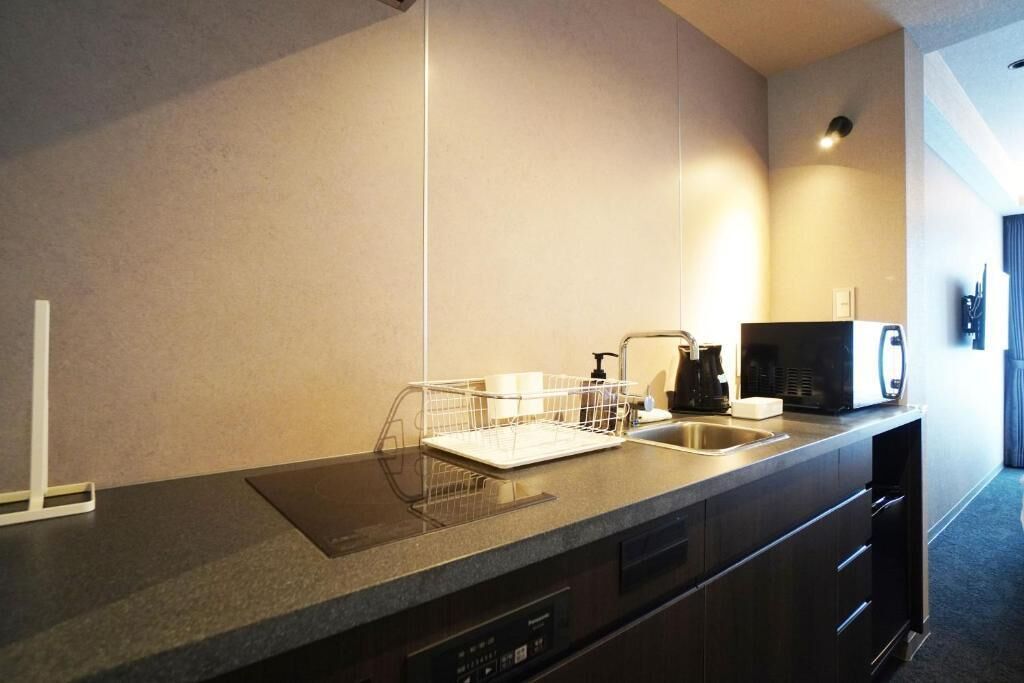 A modern kitchen with a built-in dishwasher, a coffee maker, and a microwave.