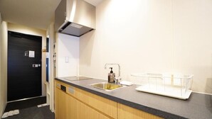Una cocina moderna con encimera negra, pileta de acero inoxidable y armarios de madera.