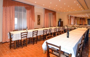 A long dining table with chairs, large windows with curtains, and a tiled floor. - Amazing home in Badia Tedalda (Badia Tedalda)