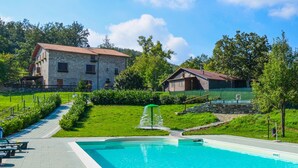 A swimming pool with a stone pathway leading to a stone building with a red roof. - Amazing home in Badia Tedalda (Badia Tedalda)