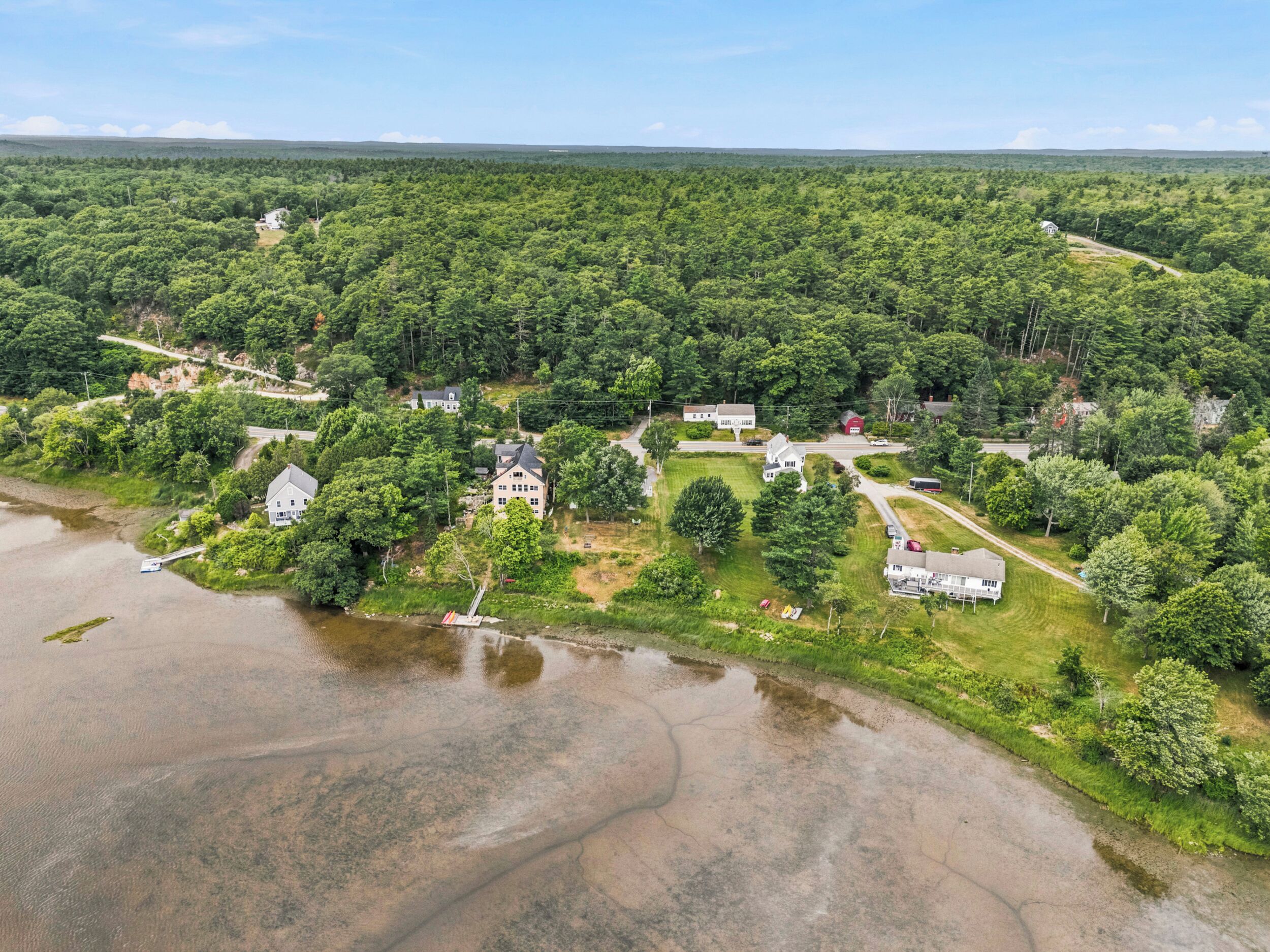 A residential area with multiple houses, a dock, and a river.