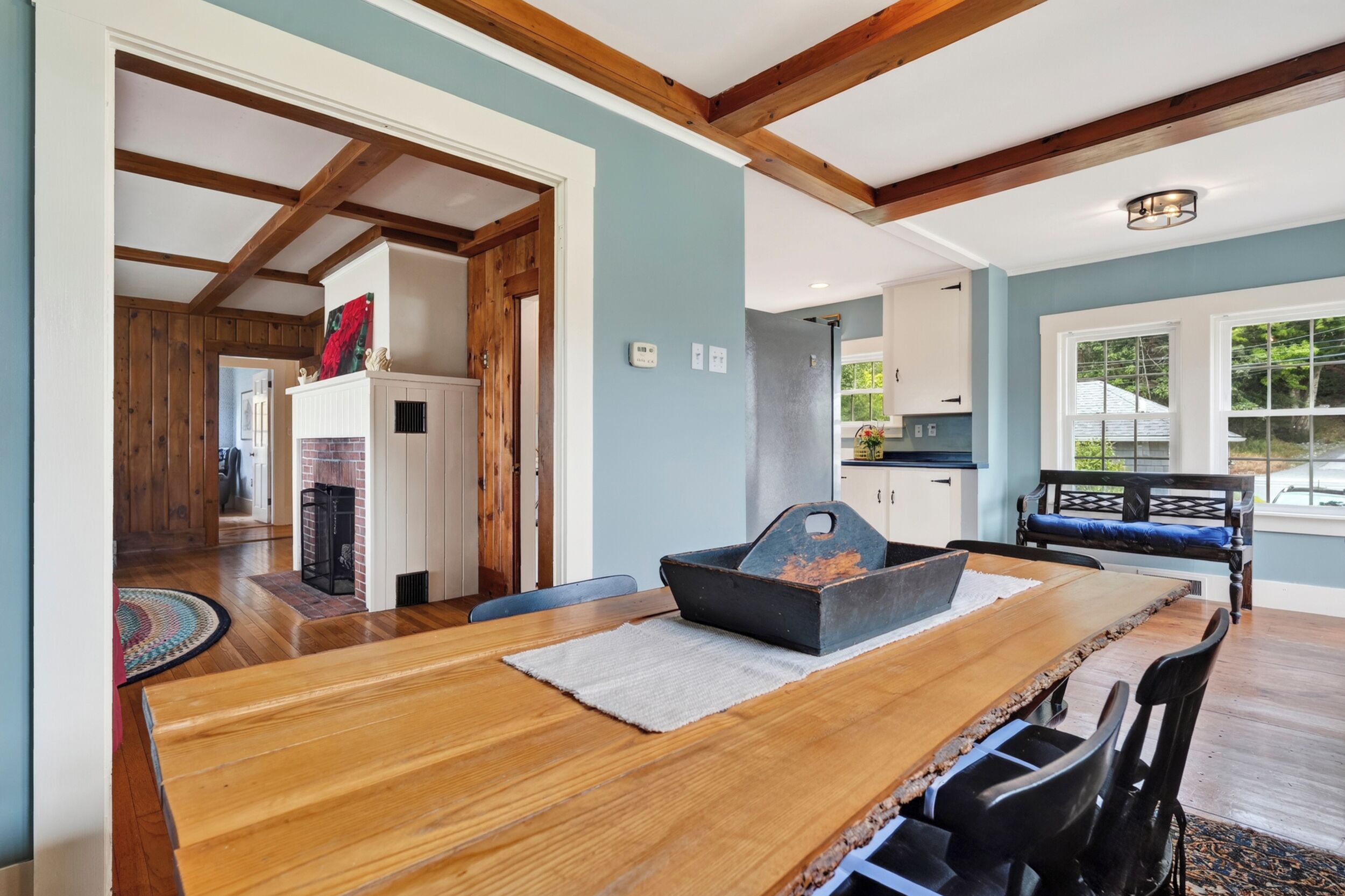 A dining area with a wooden table, chairs, and a fireplace.