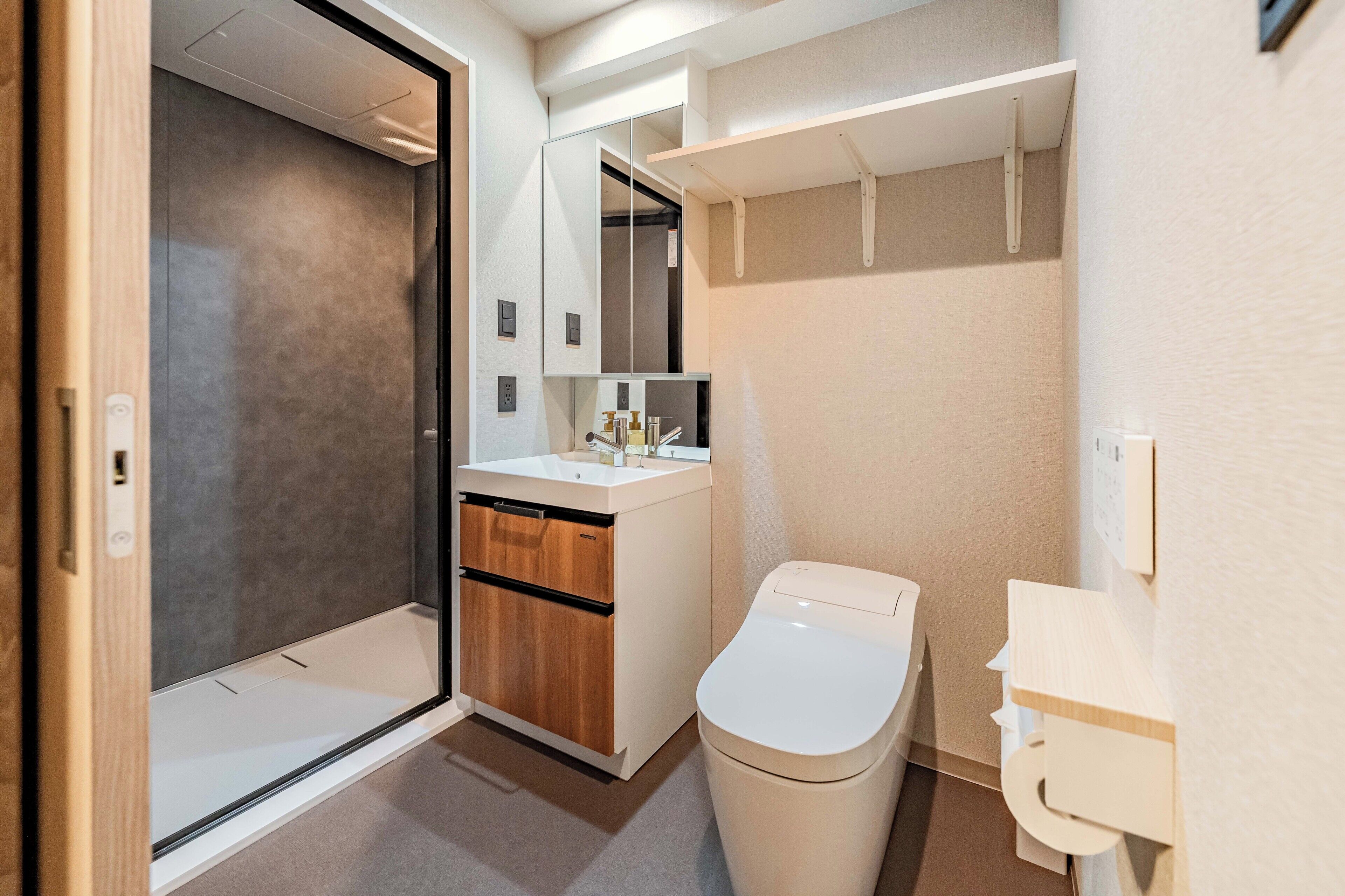 Un baño moderno con cabina de ducha, inodoro y lavabo.