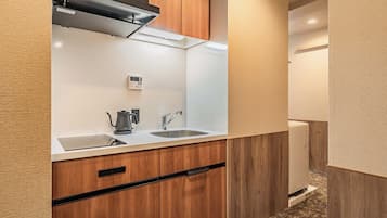 Una kitchenette compacta con estufa integrada, pileta y cafetera.