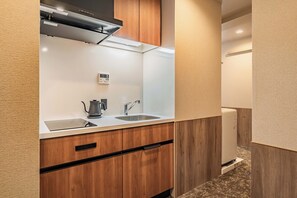 A compact kitchenette with a built-in stove, a sink, and a coffee maker. - Apartment Hotel11 Shinsaibashi AMEMURA 2 (Osaka-shi)