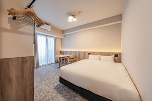 Een hotelkamer met een groot bed, een bureau en een stoel.