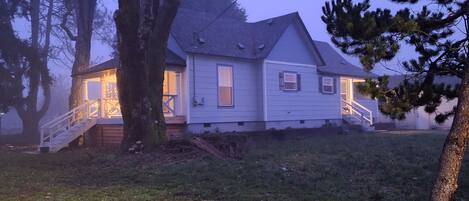 A house with a porch, a staircase, and a yard.