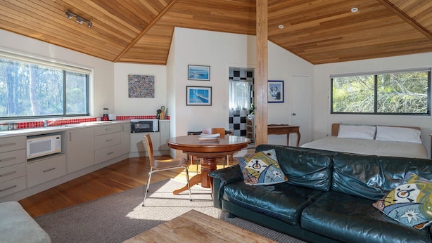 Un intérieur moderne comprenant une cuisine, un coin repas et un grand lit.
