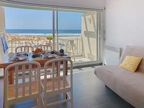 A balcony with a dining table and chairs, a sofa, and a view of the beach and ocean. - les Goelands by Interhome (Mimizan)
