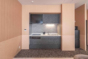 A compact kitchen with a built-in stove, sink, and a microwave. - Apartment Hotel 11 Shinsaibashi 9 (Osaka-shi)