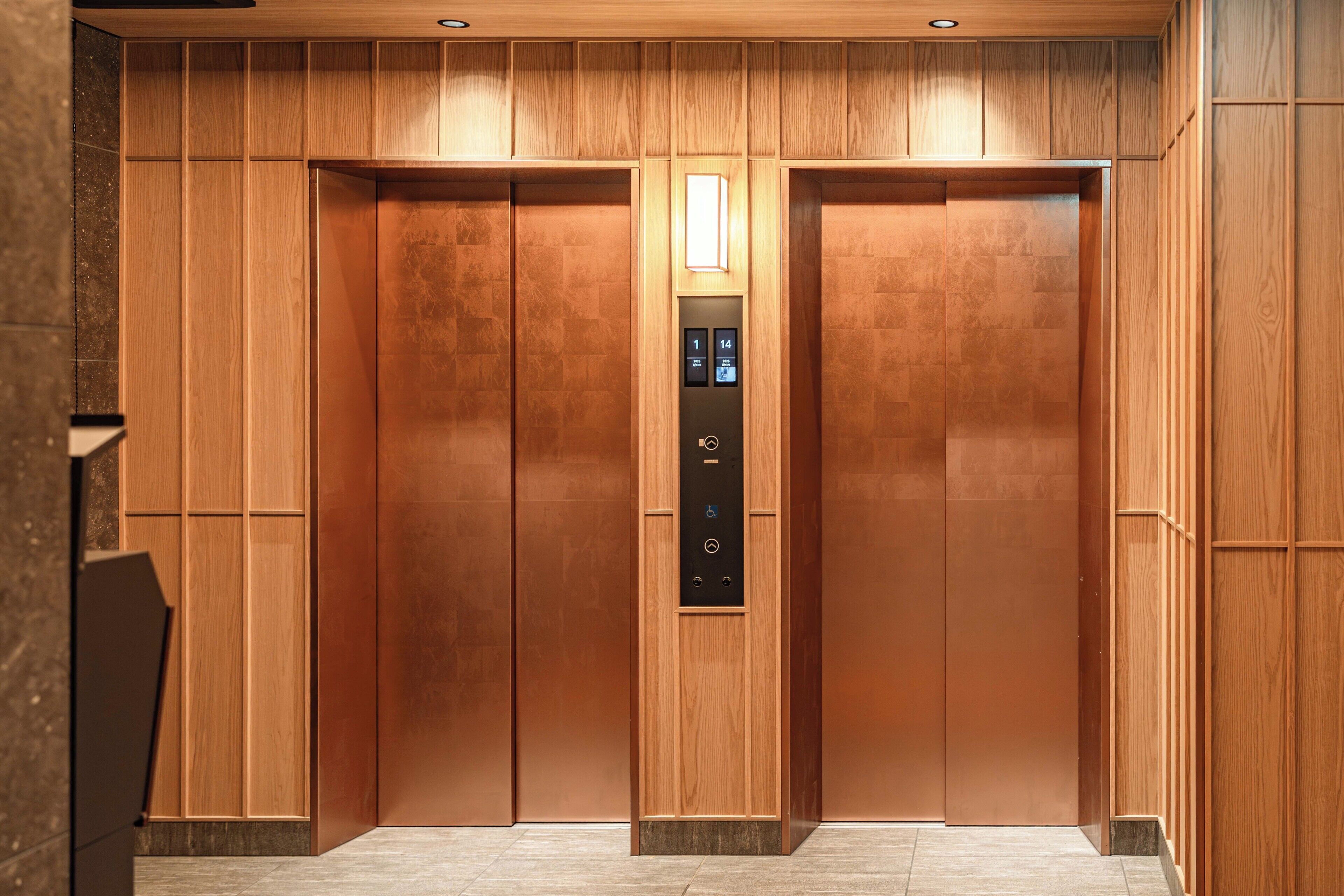 A modern elevator with a wooden finish and a digital control panel.