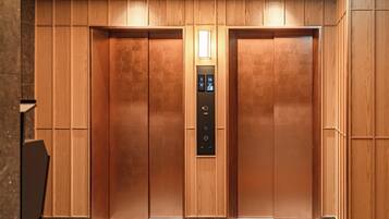 A modern elevator with a wooden finish and a digital control panel.