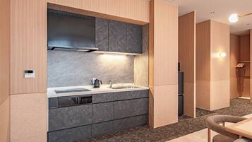 A modern kitchen with built-in appliances, a dining area with a table and chairs, and a separate living space with a sofa.