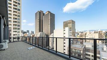 A high-rise building with a balcony overlooking a cityscape.
