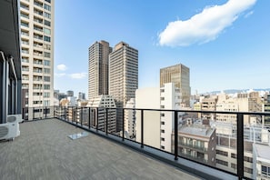 A high-rise building with a balcony overlooking a cityscape.