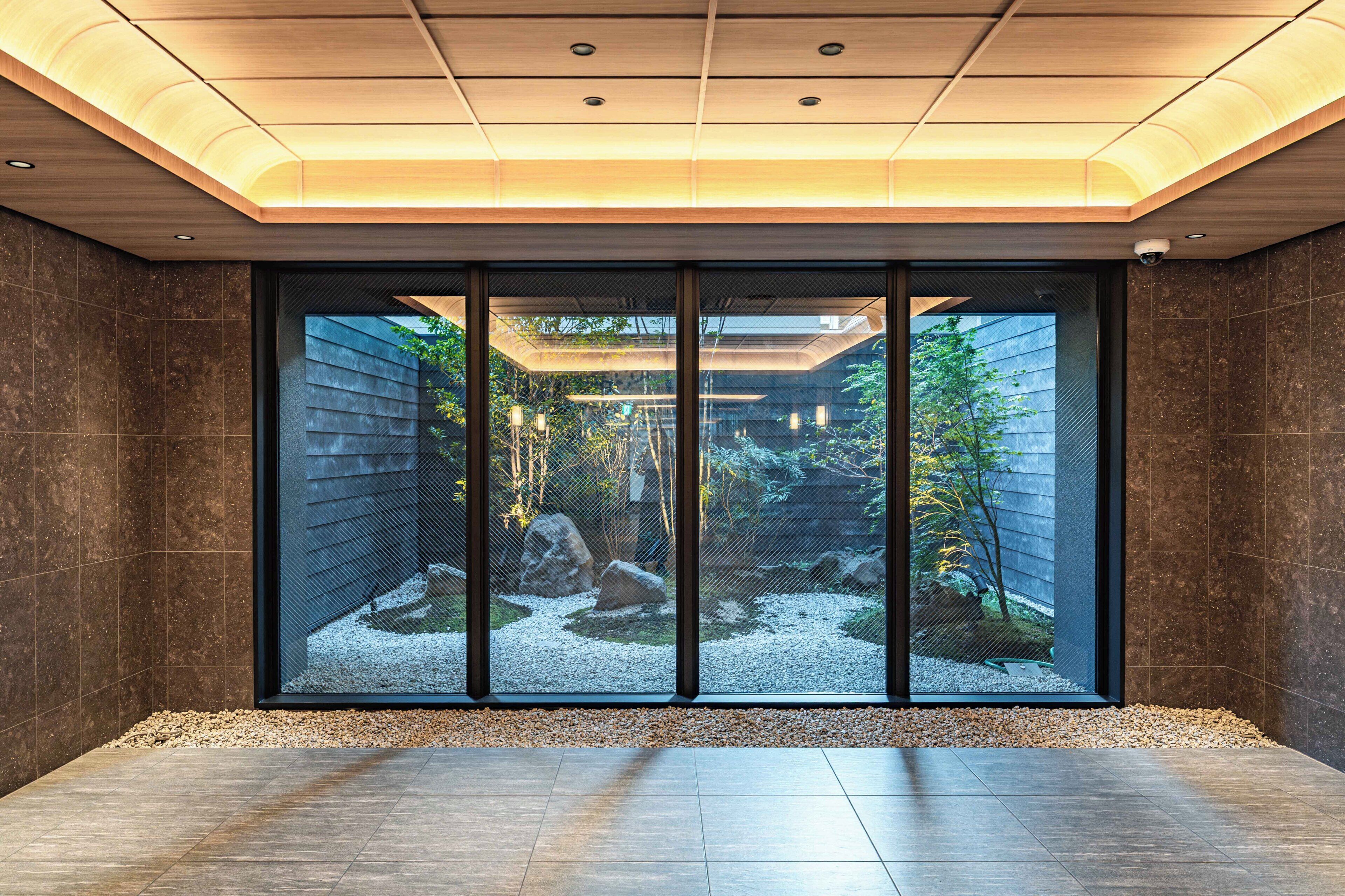 A modern interior with a large sliding glass door leading to a garden.
