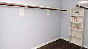 Ein Zimmer mit einem weißen Regalsystem an einer hellblauen Wand, Holzboden und weißer Decke.