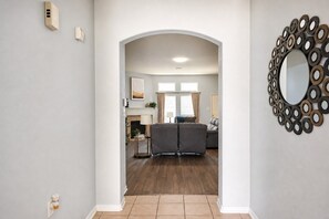 A hallway leading to a living room with a fireplace, a sofa, and a decorative mirror. - North Houston 3 beds 2baths - Sleeps 8.
Professionals, Work Groups and Families! (Houston)