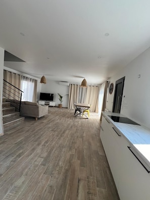 A spacious living area with a sofa, dining table, and kitchen counter. - Maison spacieuse 4 chambres climatisées proche aéroport,gare tgv et plages (Les Pennes-Mirabeau)