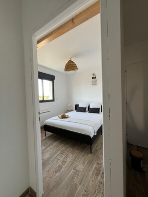 A bedroom with a bed, a window, a hanging light fixture, and a wall-mounted sign. - Maison spacieuse 4 chambres climatisées proche aéroport,gare tgv et plages (Les Pennes-Mirabeau)