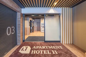 A hotel entrance with a sign reading 'APARTMENT HOTEL 11' and a number '03' on the wall. - Apartment Hotel 11 Nambaminami 6 (Osaka-shi)