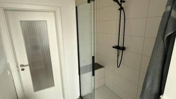 Regadera, secadora de cabello, papel de baño