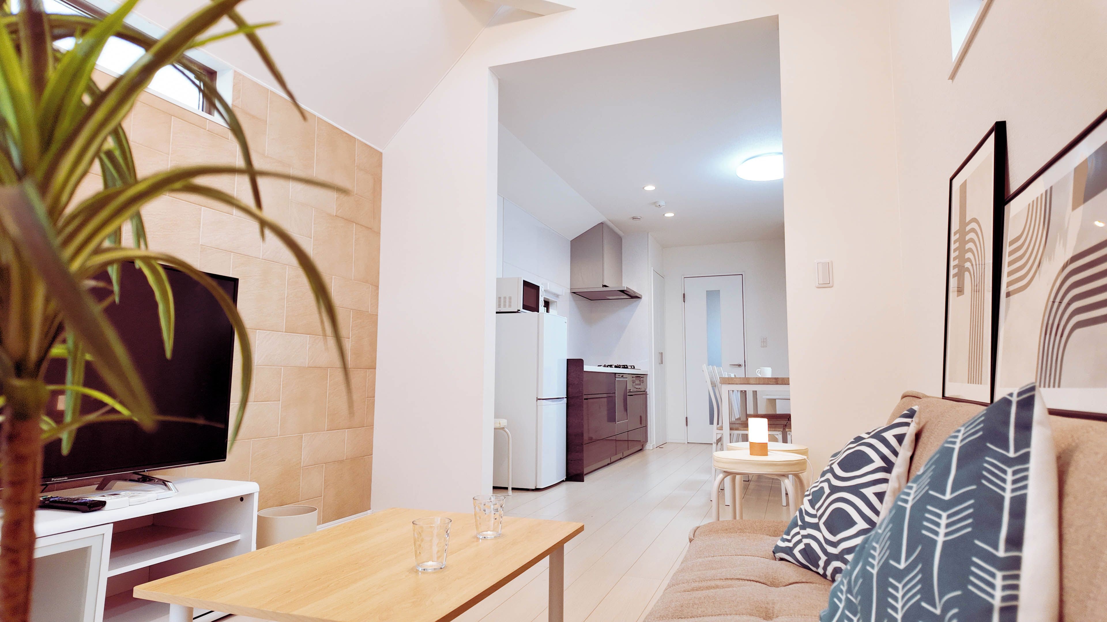 A modern living room with a television, a wooden table, and a sofa.
