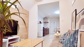 Un salon moderne avec un téléviseur, une table en bois et un canapé.