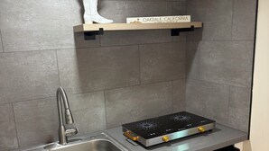 A modern kitchen with a stainless steel sink, a built-in stove, and a white cabinet. - Welcome to Oakdale, Ca Comfortable Private Bedroom/Bath,
69 miles to Yosemite. (Oakdale)
