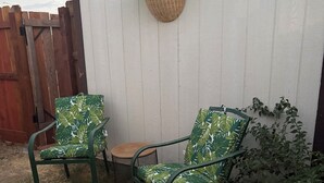 A patio area with two green metal chairs, a small round table, and a hanging plant. - Welcome to Oakdale, Ca Comfortable Private Bedroom/Bath,
69 miles to Yosemite. (Oakdale)