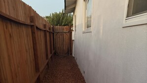 A narrow pathway with a wooden fence on one side and a white wall on the other. - Welcome to Oakdale, Ca Comfortable Private Bedroom/Bath,
69 miles to Yosemite. (Oakdale)