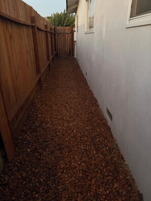 A narrow pathway with a wooden fence on one side and a white wall on the other. - Welcome to Oakdale, Ca Comfortable Private Bedroom/Bath,
69 miles to Yosemite. (Oakdale)