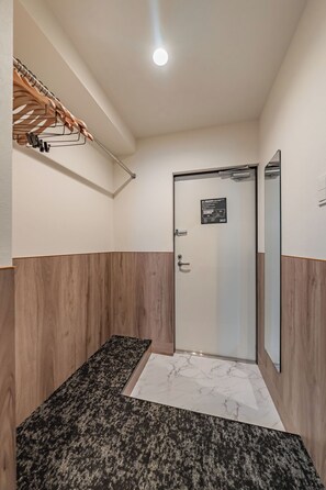 A bathroom with a shower, a mirror, and a towel rack. - Apartment Hotel 11 Kuromon 7 (Osaka-shi)