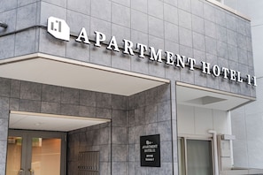Das Gebäude eines Apartmenthotels mit moderner Gestaltung, mit einem gut sichtbaren Schild, auf dem 'APARTMENT HOTEL 11' steht.