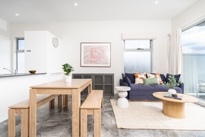 A modern living room with a sofa, coffee table, and dining area. - Quiet Turner Stay | Walk to Braddon & ANU (Turner)