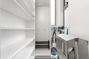A clean, modern room with white walls, a large window, and a robotic vacuum cleaner. - Quiet Turner Stay | Walk to Braddon & ANU (Turner)