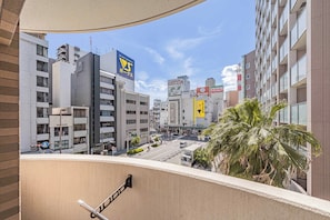A cityscape with modern buildings, a clear sky, and a palm tree in the foreground. - Apartment Hotel 11 Kuromon 8 (Osaka-shi)