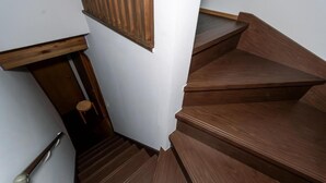 A wooden staircase with a handrail and a door at the bottom. - Nadeshiko Machiya (Fukuoka City Hakataku  Katakasu)