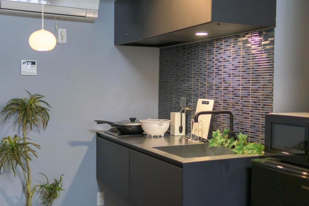 A modern kitchen with a built-in stove, a sink, and a backsplash.