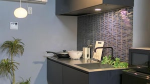 A modern kitchen with a built-in stove, a sink, and a backsplash. - Nadeshiko Machiya (Fukuoka City Hakataku  Katakasu)