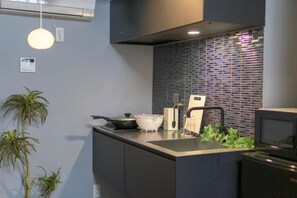 Eine moderne Küche mit eingebautem Herd, Spüle und einer Spritzschutzwand.
